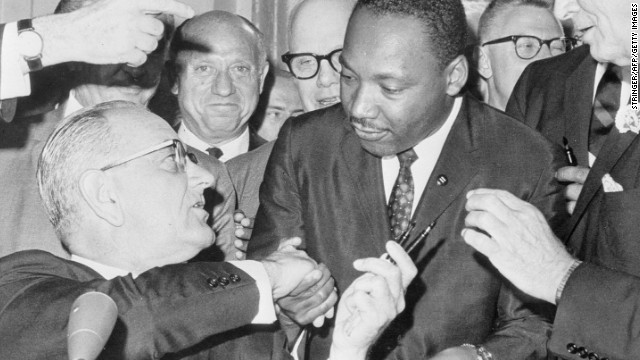 WASHINGTON, :  US President Lyndon Johnson (l) shakes hands with the US clergyman and civil rights leader Martin Luther KIng (c) 03 July 1964 in   Washington DC, after handing him a pen during the ceremonies for the signing of the civil rights bill at the White House.   Martin Luther King was assassinated on 04 April 1968 in Memphis, Tennessee. James Earl Ray confessed to shooting King and was sentenced to 99 years in prison. King's killing sent shock waves through American society at the time, and is still regarded as a landmark event in recent US history. (Photo credit should read AFP/AFP/Getty Images)