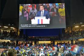 Una manifestazione a sostegno di Macron, con i tricolori francesi mescolati con le bandiere azzurre dell'UE